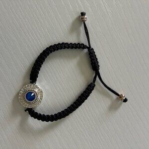 Bracelet - black braided cord with silver tone and blue rhinestone. Expandable.